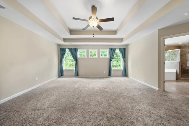 an empty room with a window and a ceiling fan