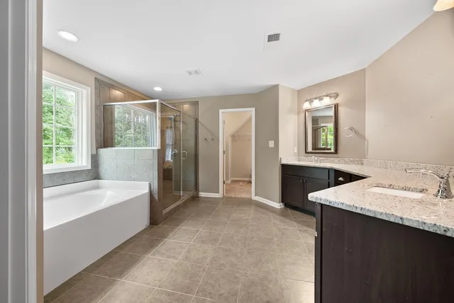 a bathroom with a tub sink and mirror