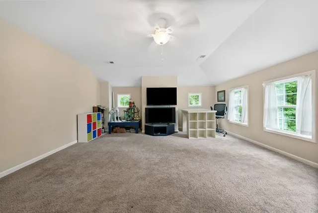 an empty room with furniture and a flat screen tv