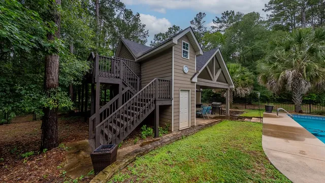 a view of a house with wooden deck and a yard
