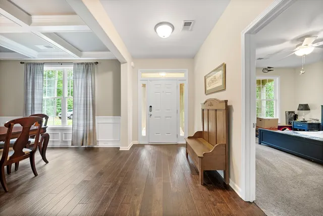 a view of a livingroom with furniture a ceiling fan and wooden floor