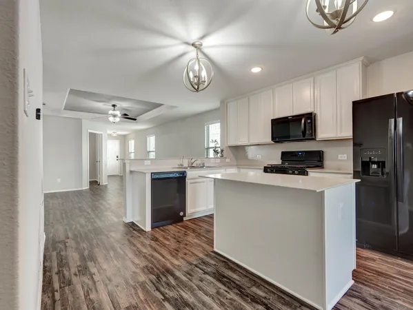 a kitchen with a refrigerator a microwave oven a sink and dishwasher with wooden floor