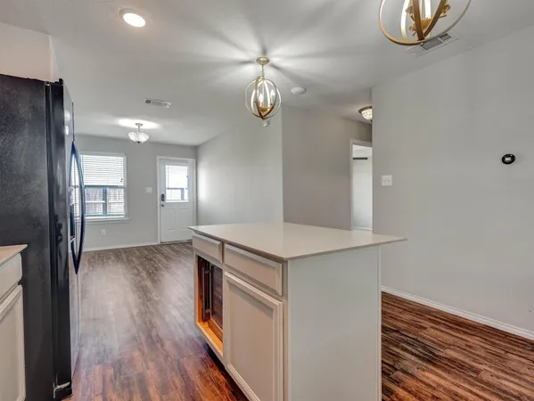 a view of a kitchen with wooden floor and cabinets