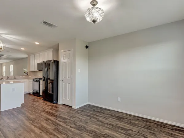 a view of kitchen with refrigerator and cabinets
