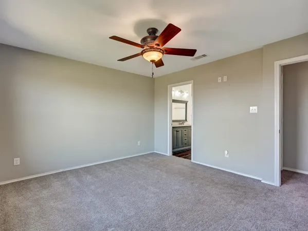 a view of an empty room and window and a ceiling fan