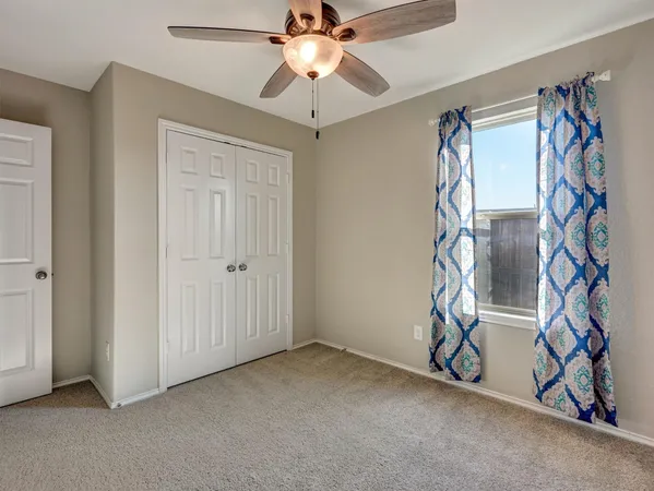 a view of an empty room with a ceiling fan