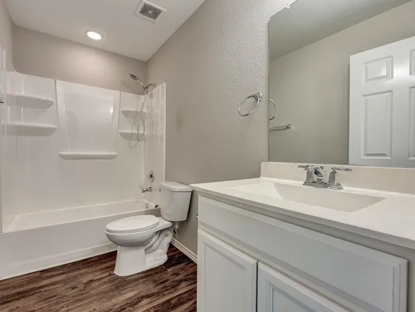 a spacious bathroom with a sink toilet a mirror and shower