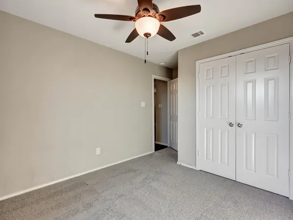 an empty room with a ceiling fan and fan