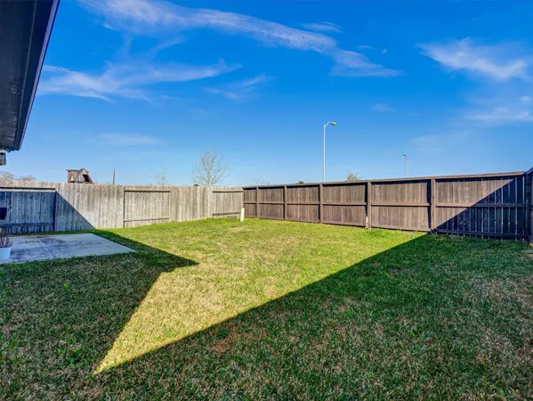 a view of a backyard with grass and entertaining space