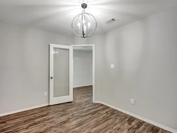 a view of wooden floor and chandelier in a room