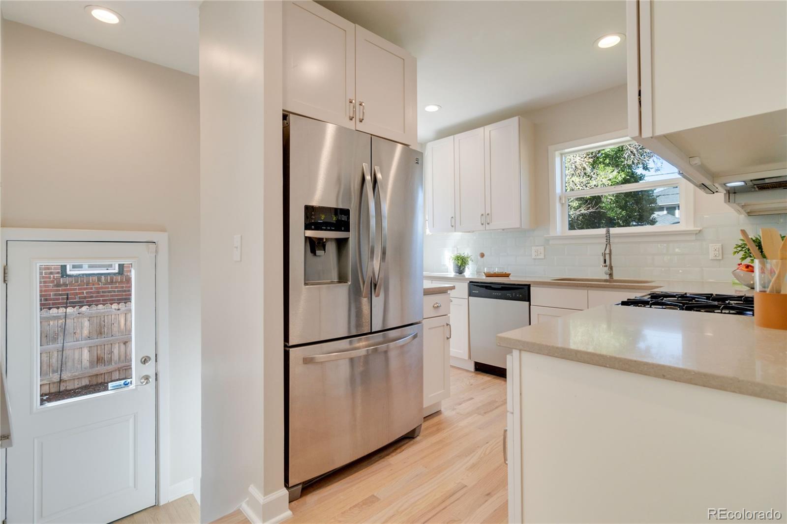 1325 Dahlia Street Denver, CO 80220 - Photo 15 of 44 a kitchen with a refrigerator a stove a sink and a potted plant