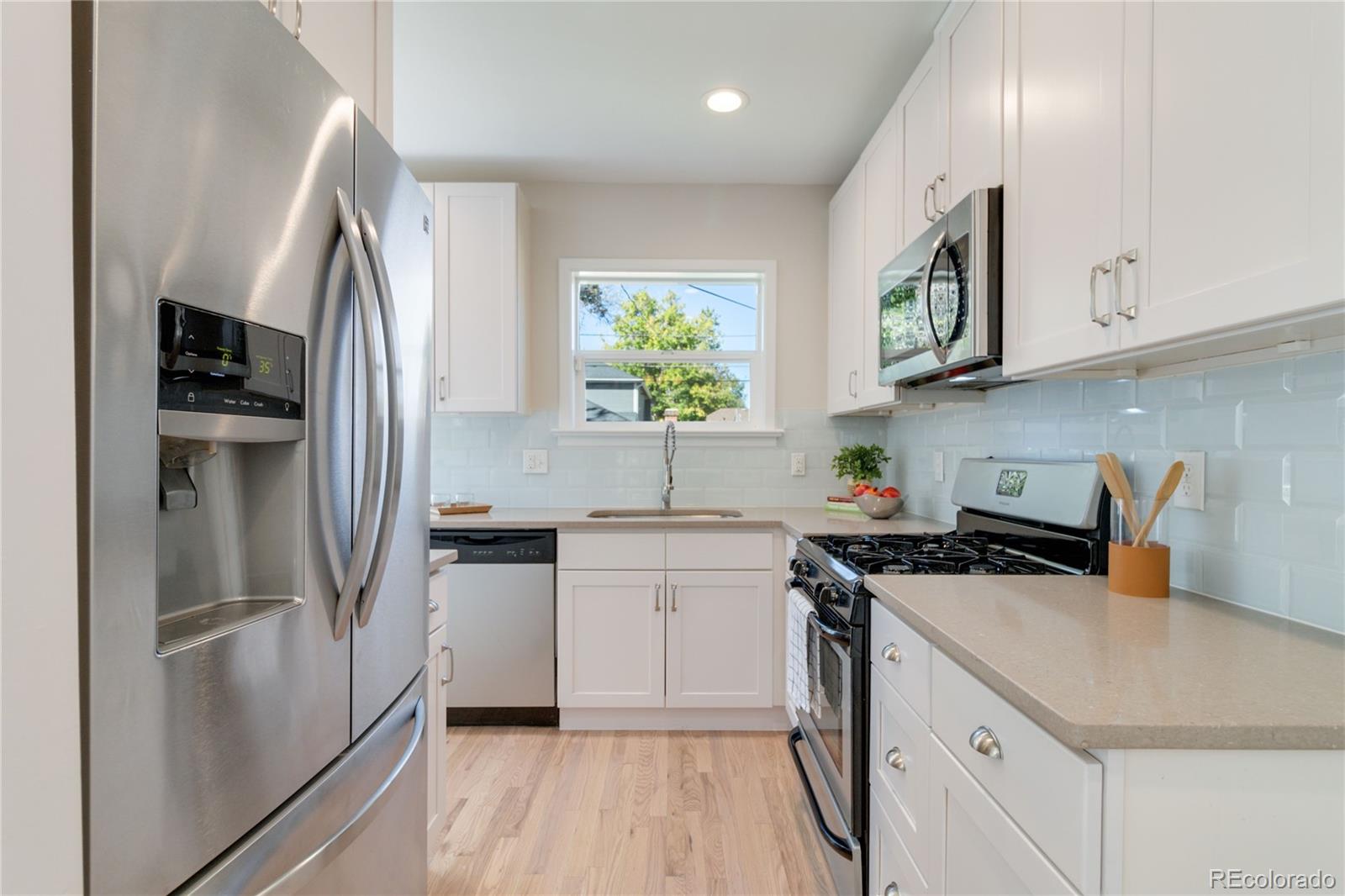 1325 Dahlia Street Denver, CO 80220 - Photo 17 of 44 a kitchen with stainless steel appliances a sink stove and refrigerator