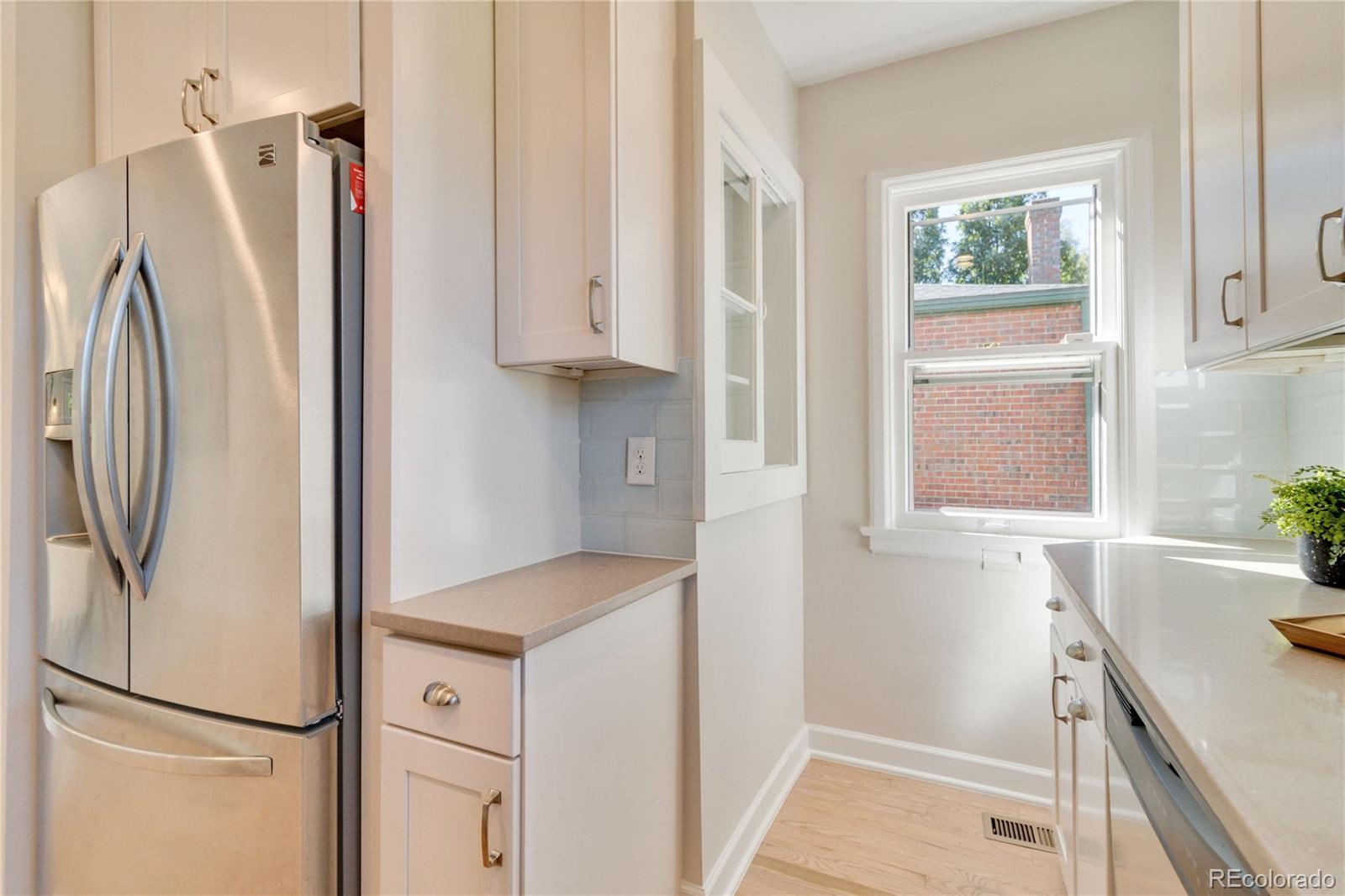 1325 Dahlia Street Denver, CO 80220 - Photo 18 of 44 a kitchen with white cabinets and refrigerator