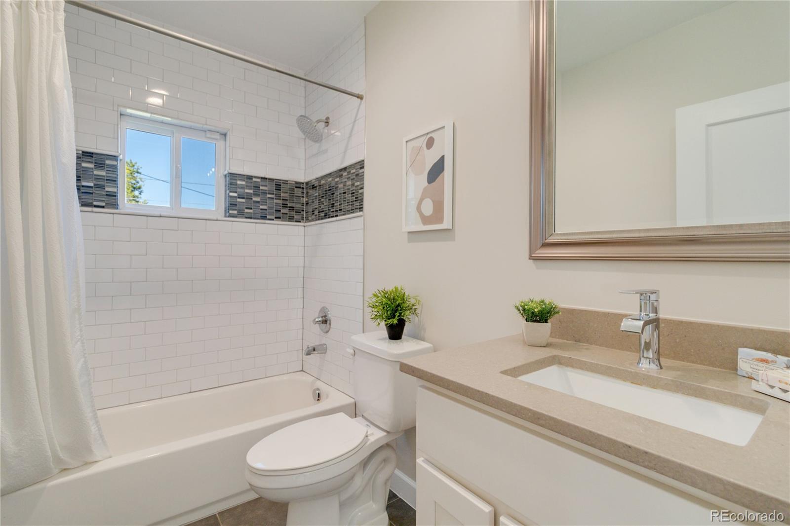 1325 Dahlia Street Denver, CO 80220 - Photo 20 of 44 a bathroom with a granite countertop sink a toilet a mirror and bathtub