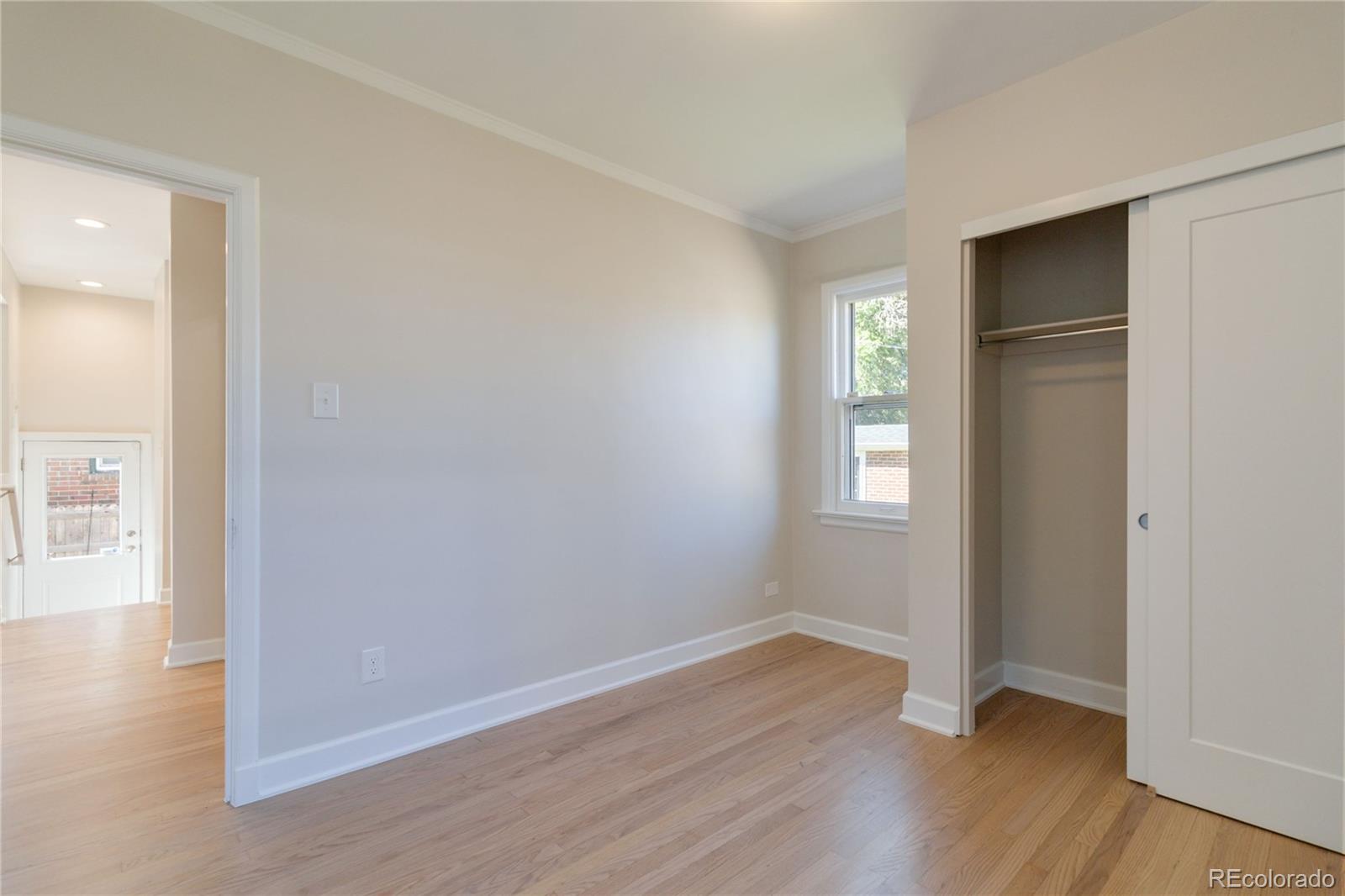 1325 Dahlia Street Denver, CO 80220 - Photo 27 of 44 a view of an empty room with wooden floor and a window