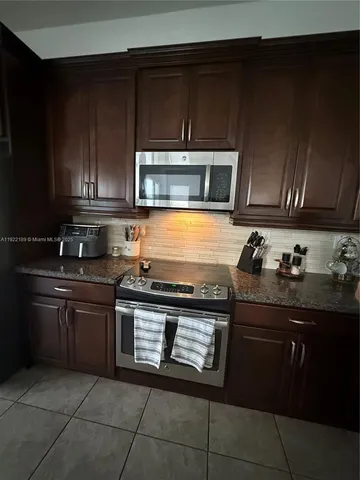 a bathroom with a granite countertop sink a toilet and a mirror