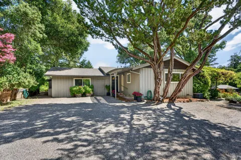 a view of a house with backyard and trees