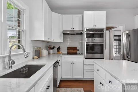 a kitchen with granite countertop a sink stainless steel appliances and cabinets