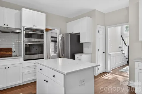 a kitchen with stainless steel appliances a microwave a refrigerator and cabinets