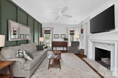 a living room with furniture a flat screen tv and a fireplace