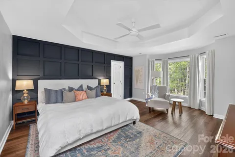 a bedroom with a large bed and wooden floor