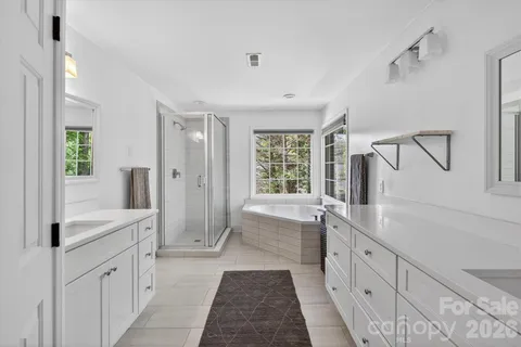 a large bathroom with a double vanity sink a large mirror and shower