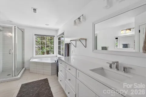 a bathroom with a tub sink and mirror