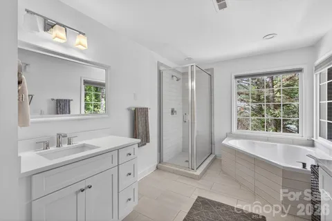 a spacious bathroom with double vanity and a mirror