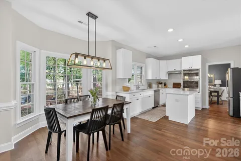 a kitchen with kitchen island wooden floor dining table and chairs