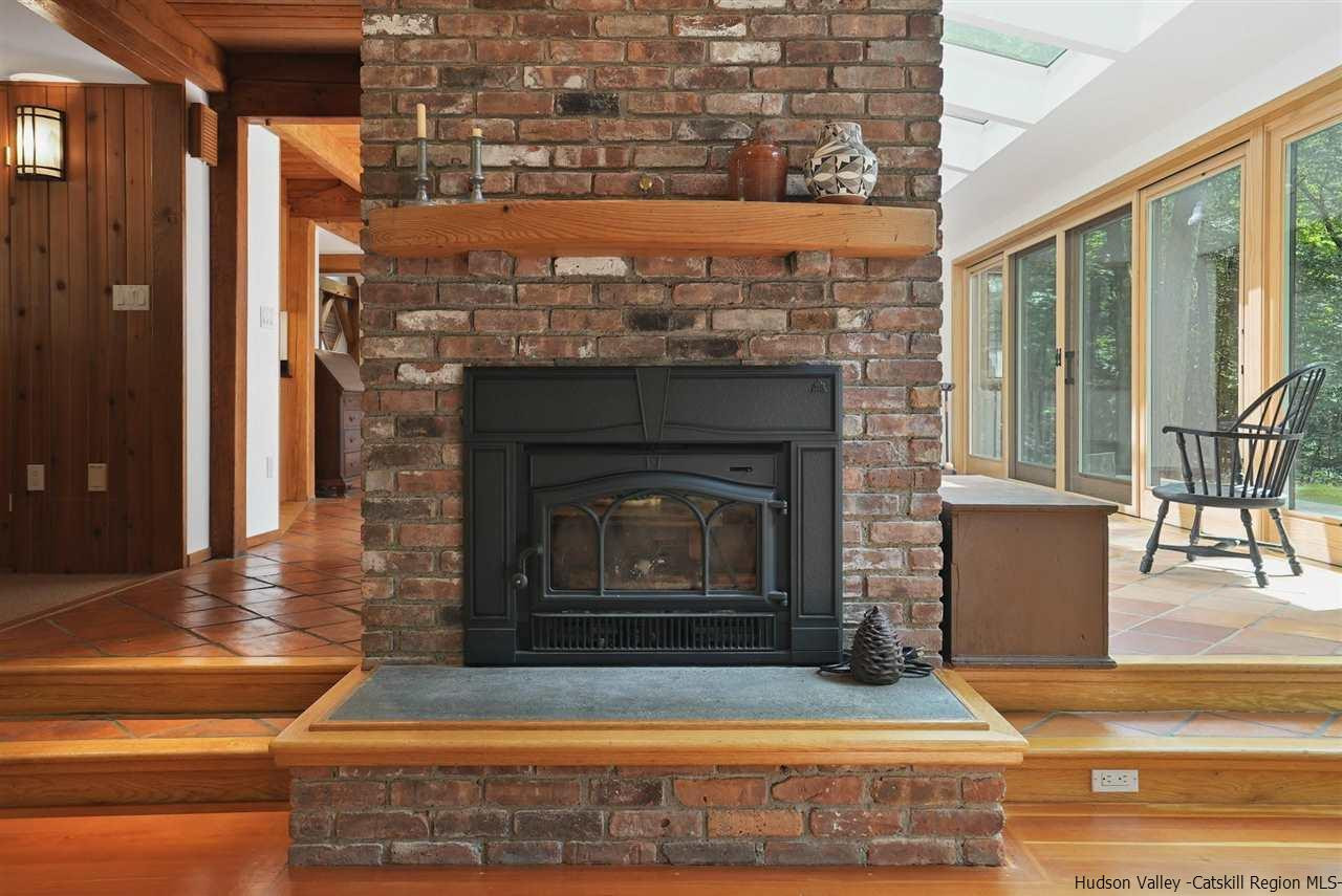 48 Rock Ridge Road New Paltz, NY 12561 - Photo 10 of 35 a living room with a fireplace and a table