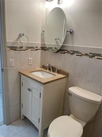 a bathroom with a granite countertop toilet a sink and mirror