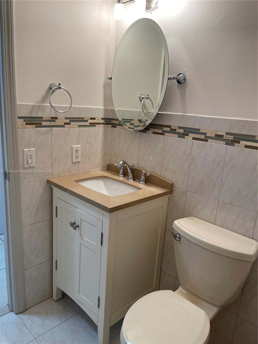 11740 Southwest 19th Street, Unit 11740 Miramar, FL 33025 - Photo 15 of 29 a bathroom with a granite countertop toilet a sink and mirror