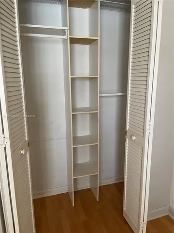 a view of walk in closet with empty racks