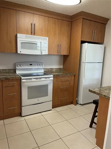 a kitchen with a stove a sink and a refrigerator