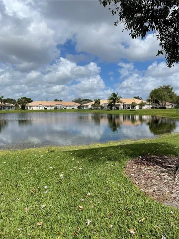 an aerial view of a residential houses with outdoor space and lake view