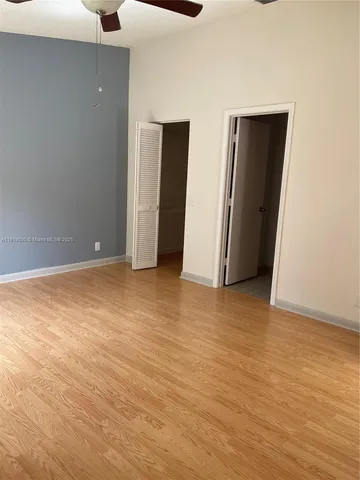 a view of an empty room with closet and a window