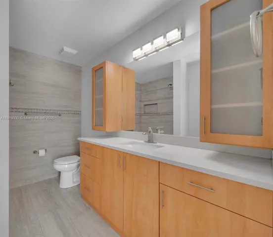 a bathroom with a toilet a sink and mirror