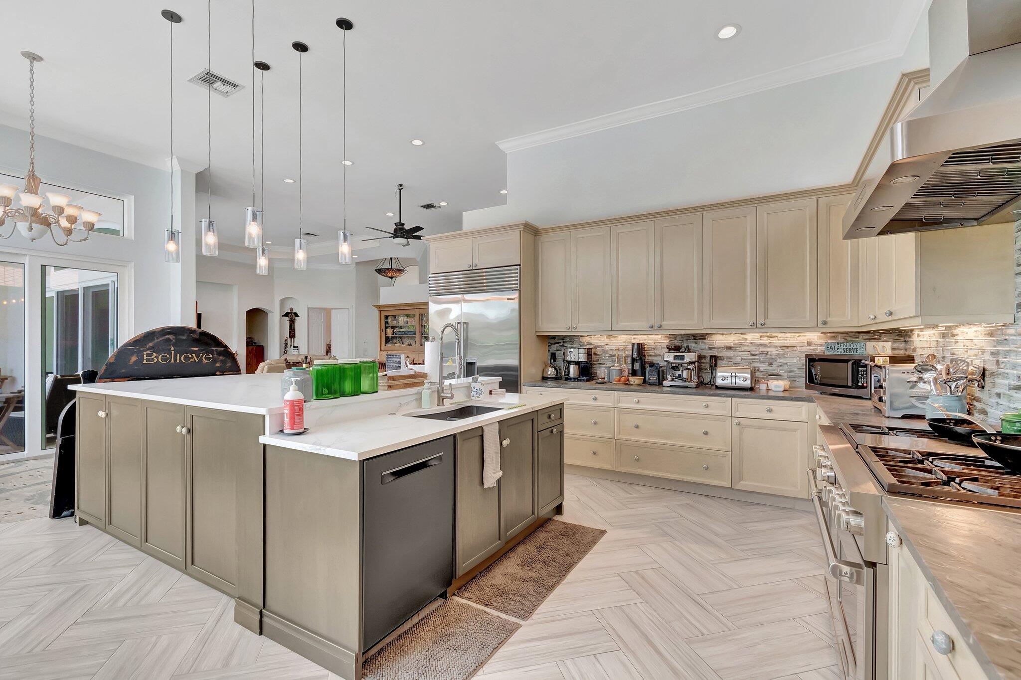 8200 Muirhead Circle Boynton Beach, FL 33472 - Photo 21 of 110 a kitchen with kitchen island granite countertop a sink a stove top oven a counter space and cabinets