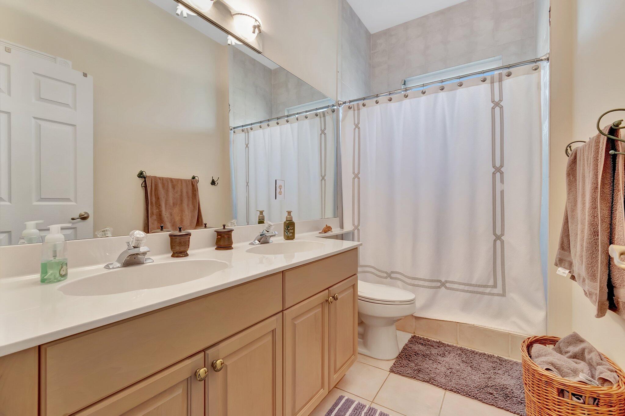 8200 Muirhead Circle Boynton Beach, FL 33472 - Photo 35 of 110 a bathroom with double vanity sink a mirror and a toilet