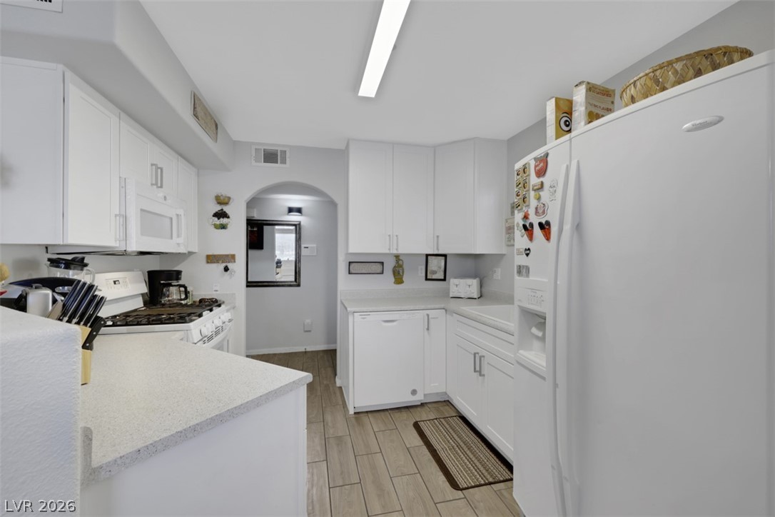 698 South Racetrack Road, Unit 1614 Henderson, NV 89015 - Photo 32 of 35 Bright, practical kitchen featuring crisp white cabinetry and durable stone-look countertops, perfect for everyday living.