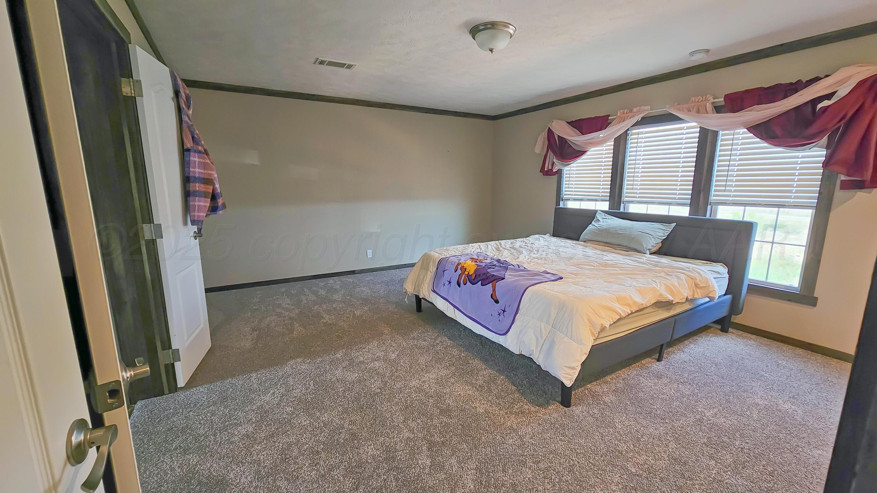 24490 RM 1061 Amarillo, TX 79124 - Photo 11 of 20 a bedroom with a bed next to a large window