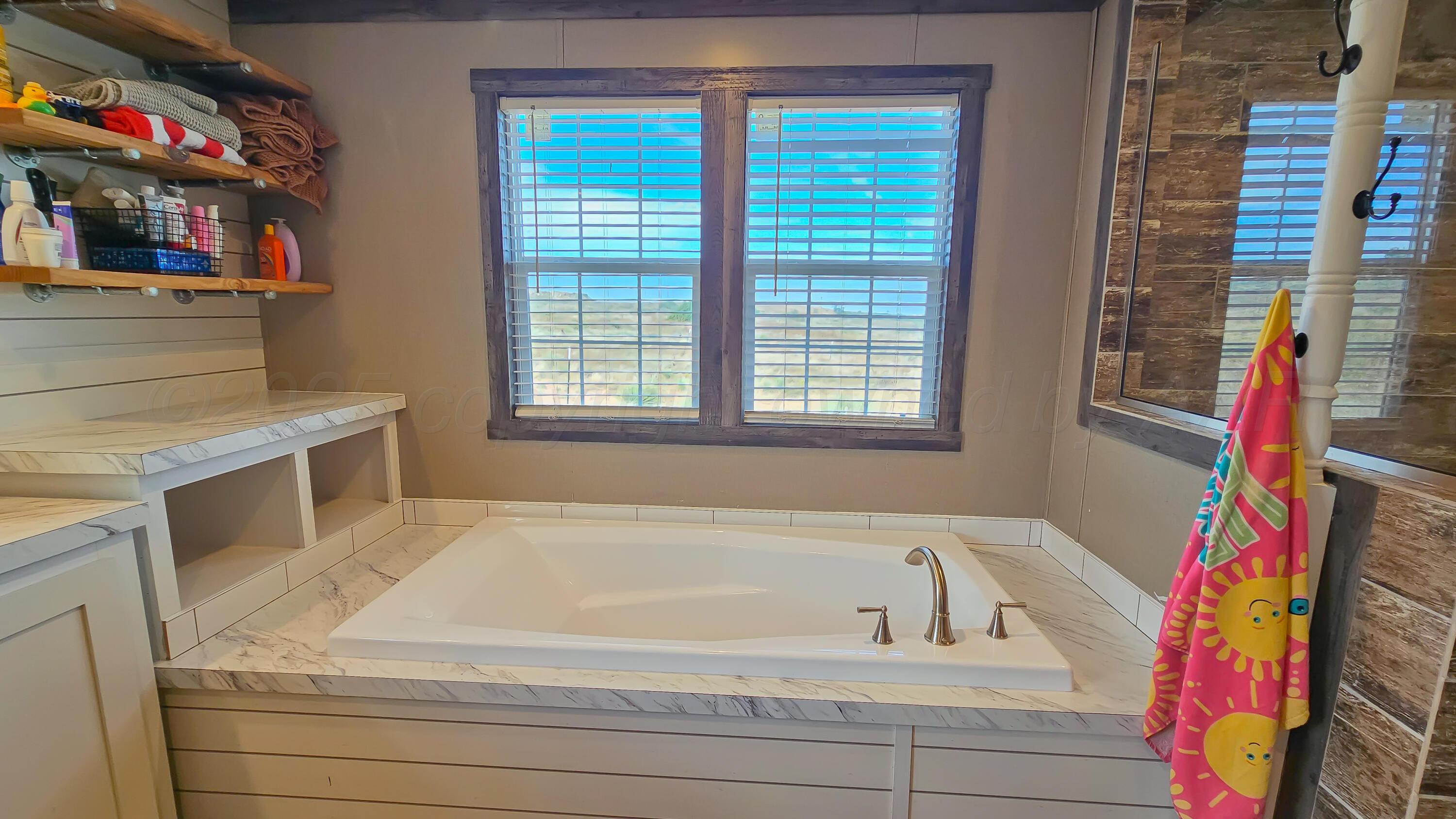 24490 RM 1061 Amarillo, TX 79124 - Photo 18 of 32 a bathroom with a tub and a window
