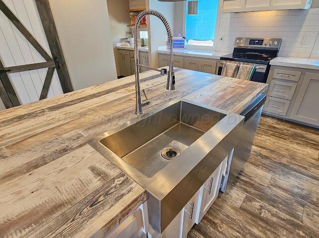 24490 RM 1061 Amarillo, TX 79124 - Photo 8 of 20 a kitchen with a stove two sinks a washer and dryer