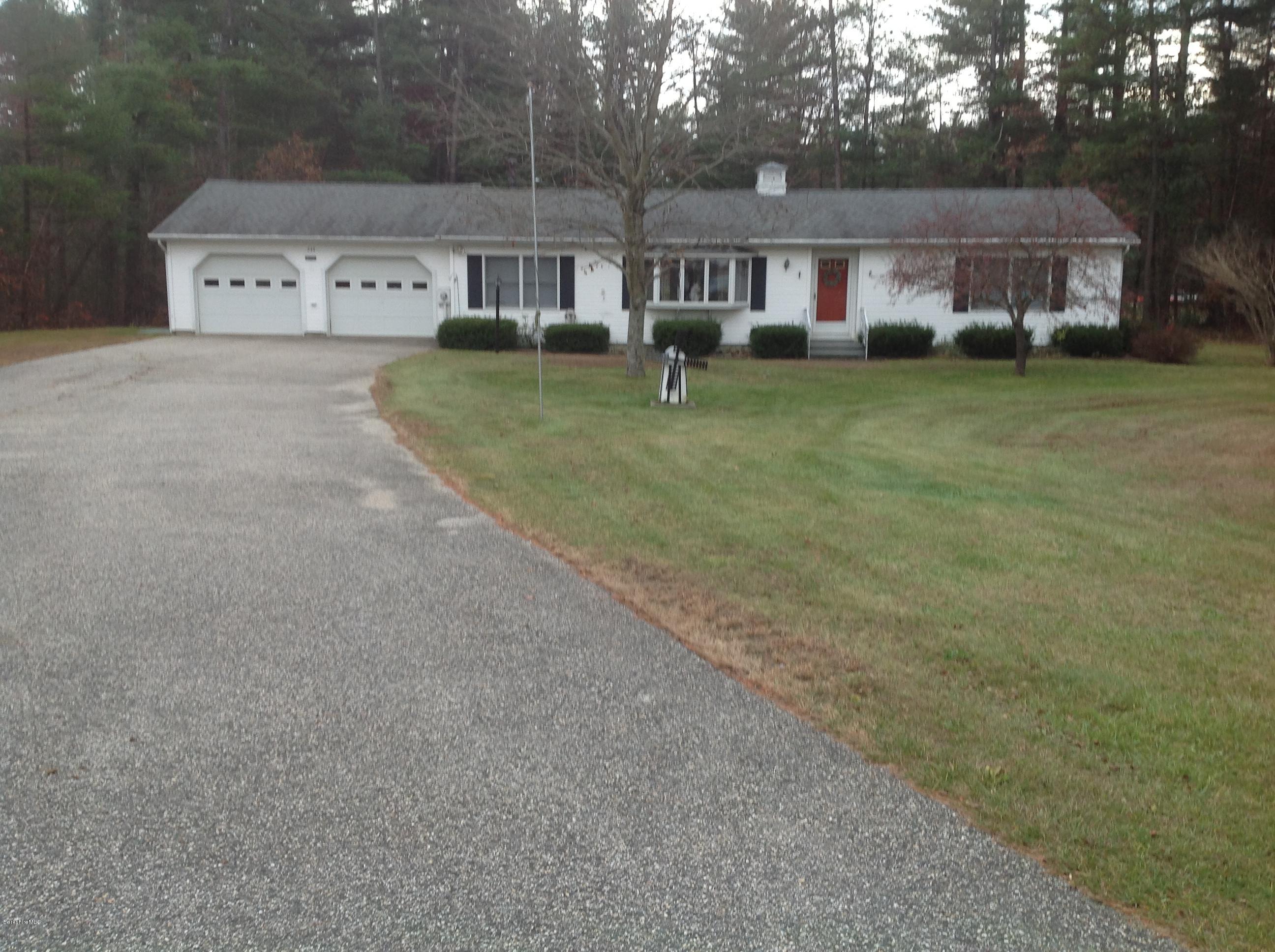 a front view of a house with a garden and trees