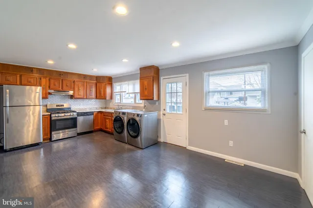 a kitchen with stainless steel appliances a refrigerator a sink a stove a microwave and cabinets