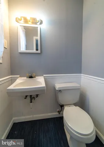 a bathroom with a sink toilet and a mirror