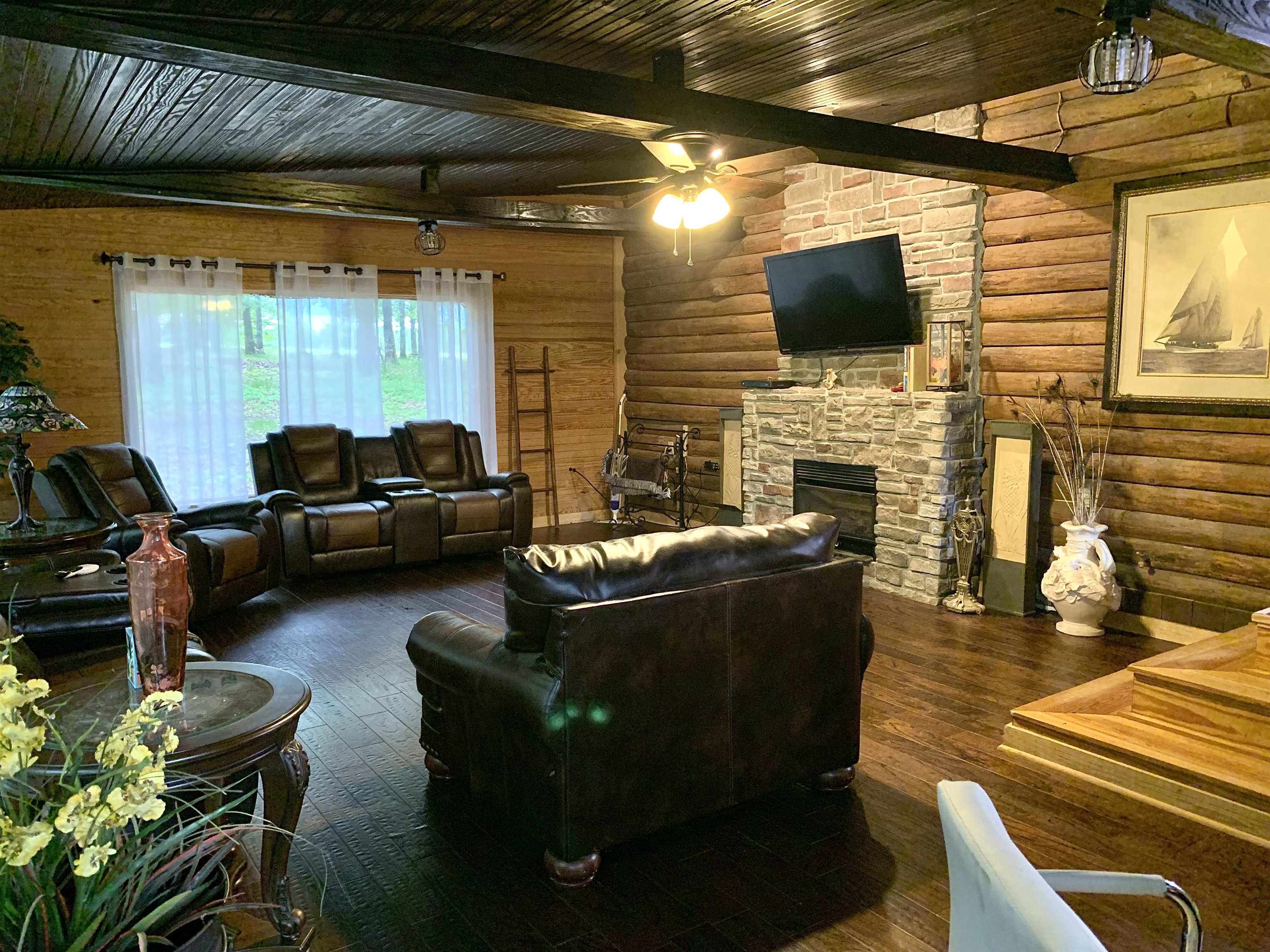 4560 Bishop Road Middleton, TN 38052 - Photo 17 of 40 Living area featuring beam ceiling, rustic walls, a ceiling fan, and wood-type flooring