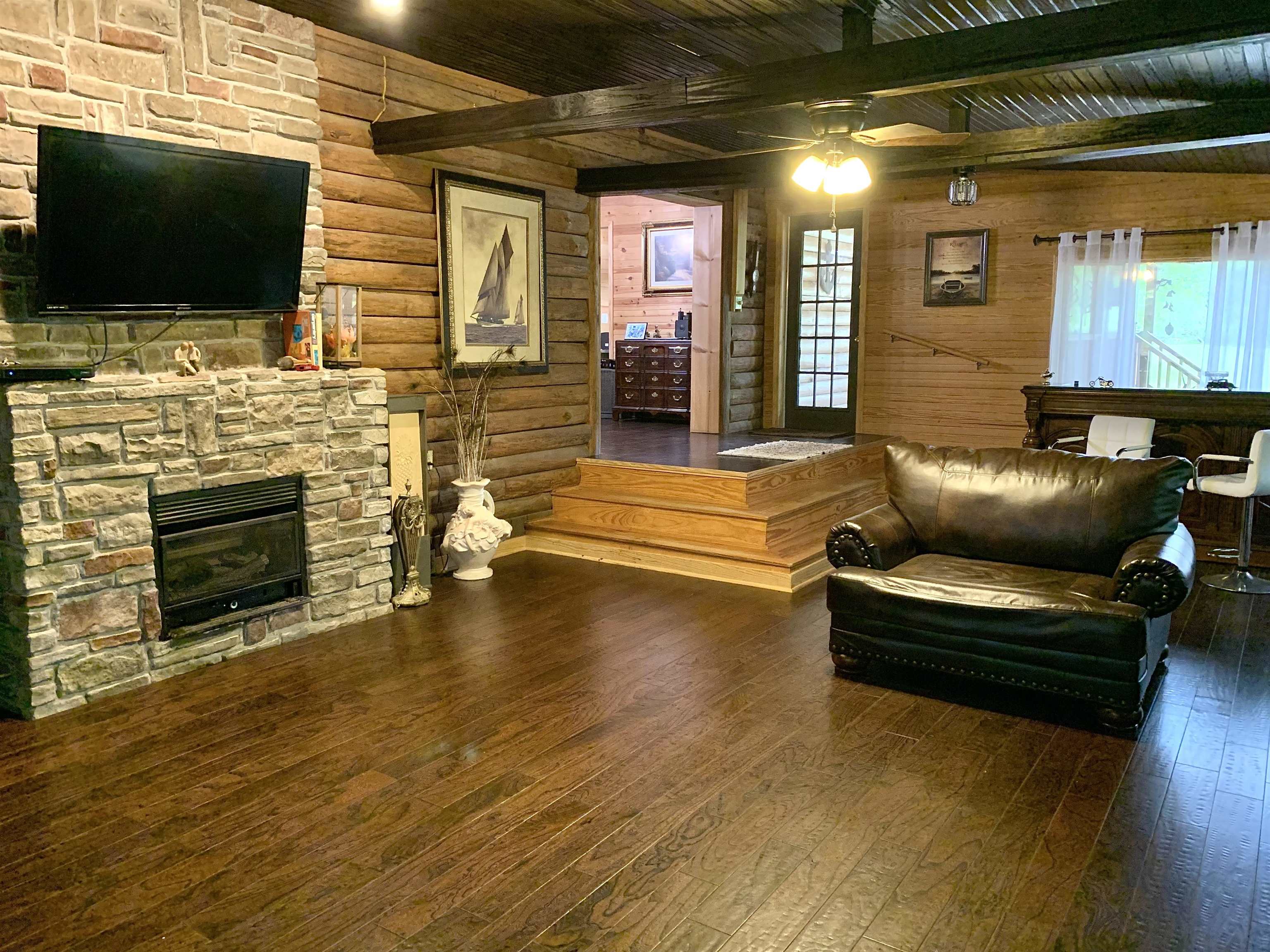 4560 Bishop Road Middleton, TN 38052 - Photo 19 of 40 Living area with wood ceiling, a fireplace, ceiling fan, beamed ceiling, and hardwood / wood-style flooring