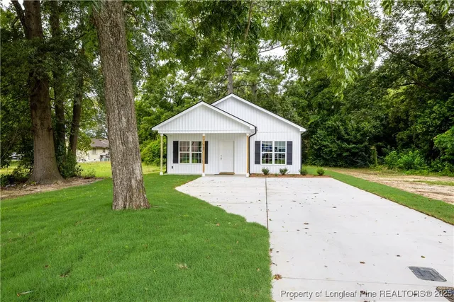 a front view of a house with yard and green space