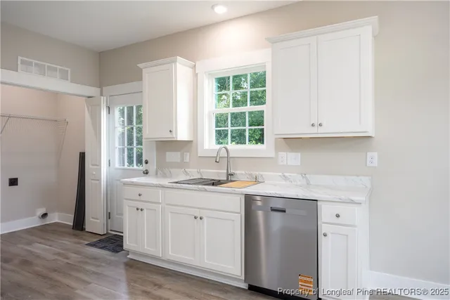 a kitchen with granite countertop a sink stainless steel appliances and cabinets